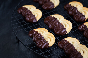 Homemade chocolate dipped shortbread cookies on dark background