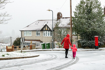 Mother and child crossing the street on a snowy day in London. Photo taken at Greenwich in February...