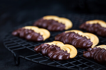 Homemade chocolate dipped shortbread cookies on dark background