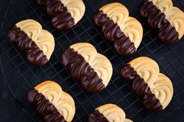 Homemade chocolate dipped shortbread cookies on dark background