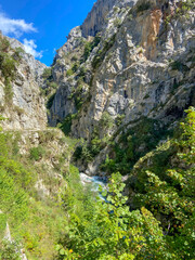 The Cares river canyon along the Cares Route in the heart of Picos de Europa National Park, Spain. Narrow and impressive canyon between cliffs, bridges, caves, footpaths and rocky mountains.
