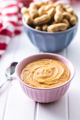 Peanut butter in bowl and peanuts