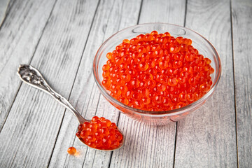 Red caviar in a crystal bowl on a black background. Delicacy product of the highest quality.