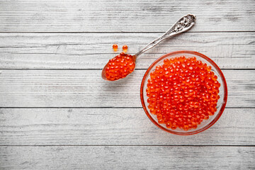 Red caviar in a crystal bowl on a black background. Delicacy product of the highest quality.