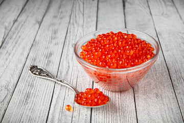 Red caviar in a crystal bowl on a black background. Delicacy product of the highest quality.