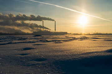 Smoke from industry plant chimney over sunrise background. Energy generation and air environment...