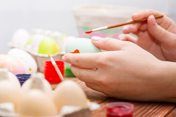 Obraz na płótnie Canvas Mother and son are painting Easter eggs. Preparing decorations for Easter, creativity with children, traditional symbols. Preparing for Easter