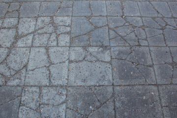 The sidewalk is paved with square decorative tiles.