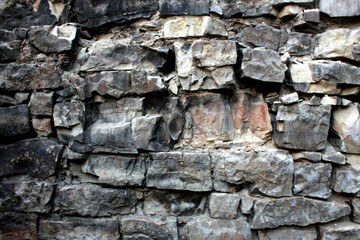 An old burnt-out wall made of limestone blocks.