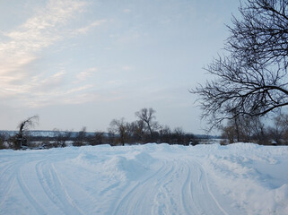 Winter landscape. A distant village in the cold part of the planet. White snow covered road