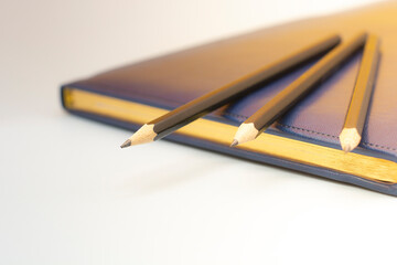 dark blue leather notebooks and three pencils. Preparing for a business meeting. Business concept