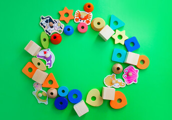 children's toys are laid out on a green background top view. space for text