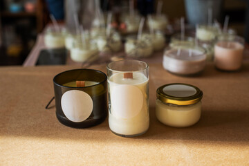 wooden wick candles. Handmade candle from paraffin and soy wax in glass with flowers and leaf on...