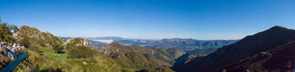 Fototapeta na wymiar Panoramic view from Reina Lookout (Mirador de la Reina) over the mountain tops of Picos de Europa National Park, Asturias, Spain. This viewpoint is on the Los Lagos road.
