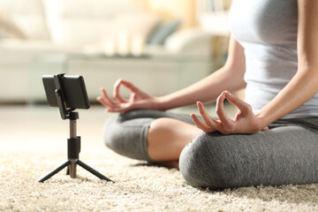 Female doing yoga watching online tutorial on mobile phone
