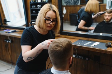 Barber Woman Cutting Man Hair at the Barbershop. Woman Working as a Hairdresser. Small Business Concept.