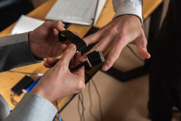 close-up, girl puts on a man's hand sensors for passing a polygraph, a truth detector. The concept of passing a polygraph