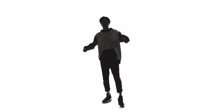 Dancer shadow. Hip hop performance. Funky choreography. Dark contrast backlit silhouette of Asian guy enjoying energetic hype movements isolated on white copy space background.