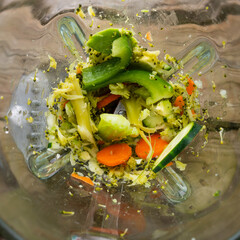 Green fresh smoothie, with spinach, cucumber, bell peppers and celery and carrots blended in a...