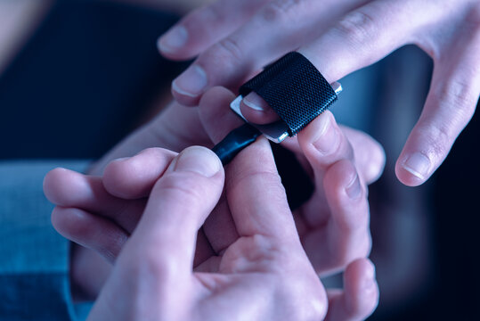 close-up, girl puts on a man's hand sensors for passing a polygraph, a truth detector. The concept of passing a polygraph