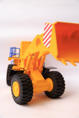 Obraz na płótnie Canvas Scale model of a yellow single-bucket loader on white background