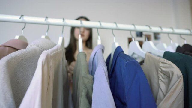 Woman is  Looking For Clothes. Close-up Of Clothe in a Rack
