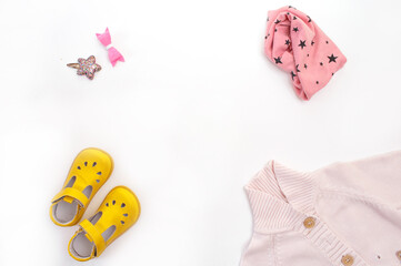 children's clothing and shoes on a white background top view. Space for the text.