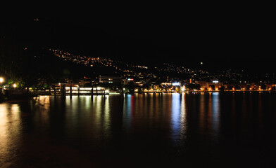 Fototapeta na wymiar Harbor in Locarno with the Lago Maggiore lake at night, with boats