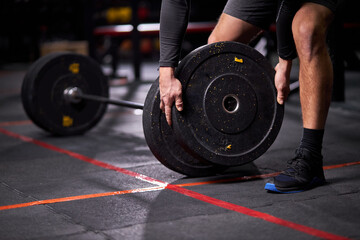 Sportsman powerlifter preparing for deadlift of barbell during competition, spending time in gym...