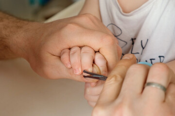 Father cutting baby's nails. Toddler manicure, baby's hygiene and health care.