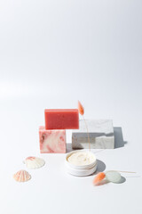 Composition with natural cosmetics, soap and scrub for spa treatments. Vertical frame on a light background, with hard shadows