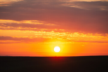 Magical colorful sunset with red scenic clouds.