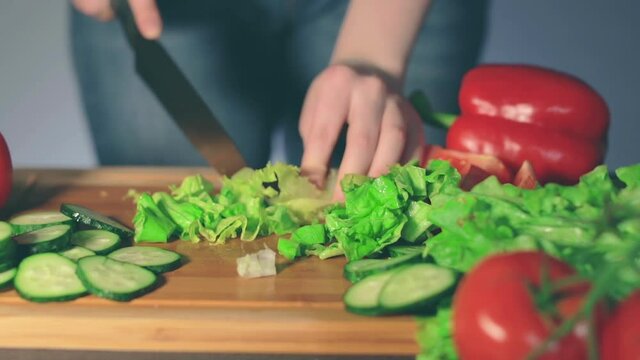 Woman in Blue Jeans is Cutting Vegetables at Home. Housewife is Preparing Ingredients for Something Dietary. Healthy Food Concept