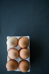 Fresh farm eggs in carton on kitchen bench