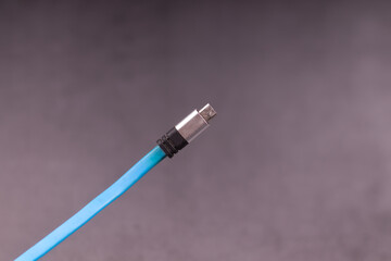 blue charging wire against a gray surface, end on the phone side
