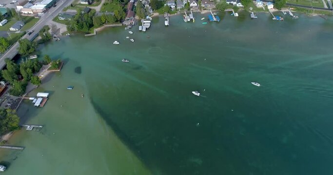 Aerial view of boats idling along in crystal clear Torch lake waters near sandbar in Michigan.  