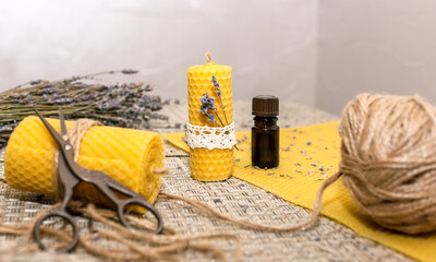 Production concept DIY. Yellow candles made from natural beeswax with lavender