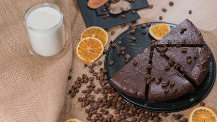 slices of chocolate brownie cake with glass of milk and coffee beanas on wooden table