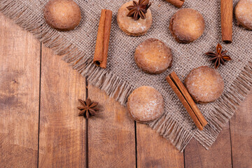 cookies, cinnamon and stars are mixed and stacked on a gray fringed rug, against a wooden surface