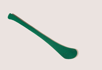 A green stick – hurleyn, a top view against beige background.