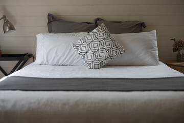 Bed with white linen lit by natural light 