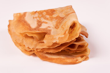 pancakes are folded in a triangle and in one pile side view and slightly from above