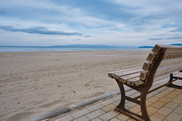 Great sea view, and beach together with wooden bench and its metal side exposed to corrosion and...