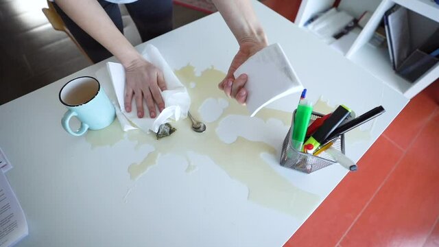 Office manager Spilled Tea On The Work Desk 
Saving Important Documents. Cleaning The work Place