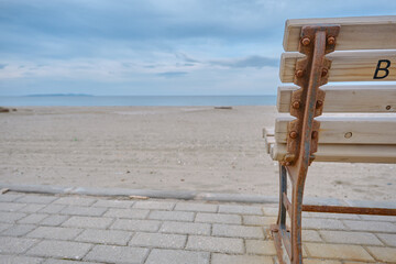 Great sea view, and beach together with wooden bench and its metal side exposed to corrosion and...