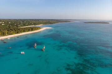 Aerial view of wooden sail boats near Wide White Coastal Beach Line in Kendwa village, Zanzibar