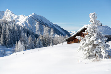 Beautiful winter mountain landscape with snowcapped wooden hut