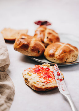 Close Up Of Traditional Easter Hot Cross Bun With Butter And Jam