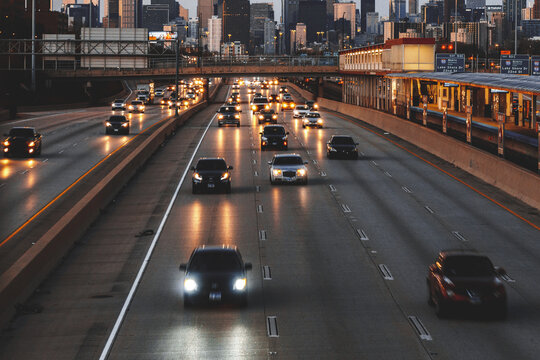 City skyline and cars driving along freeway at sunset, Chicago, Illinois, USA