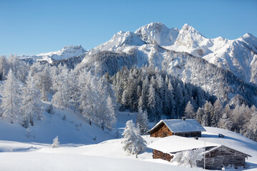 Beautiful winter mountain landscape with snowy forest and traditional alpine chalet. Sunny frosty...